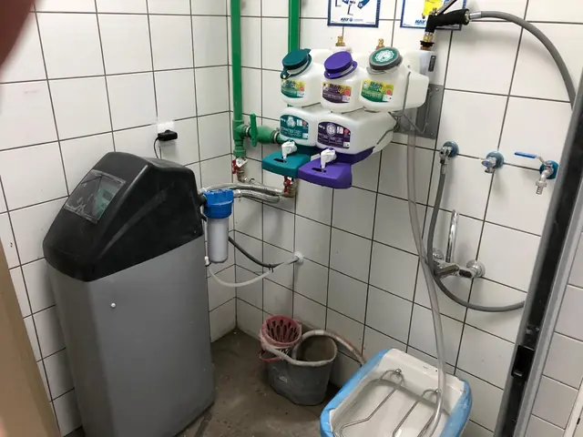 Descalcificador, filtro y dosificadores de producto instalados en el cuarto de limpieza de un local