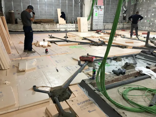 Red horizontal de desagües de PVC sobre aislamiento XPS, replanteada con láser antes del recrecido